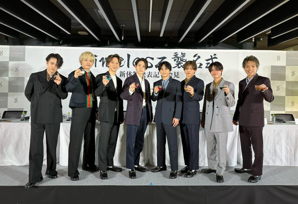スーツ姿でグラスを持って並ぶtimeleszのメンバー8人