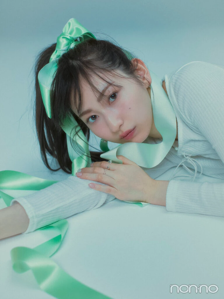 ポニーテールにロングリボンをつけ、寝そべってこちらを見る植村あかり