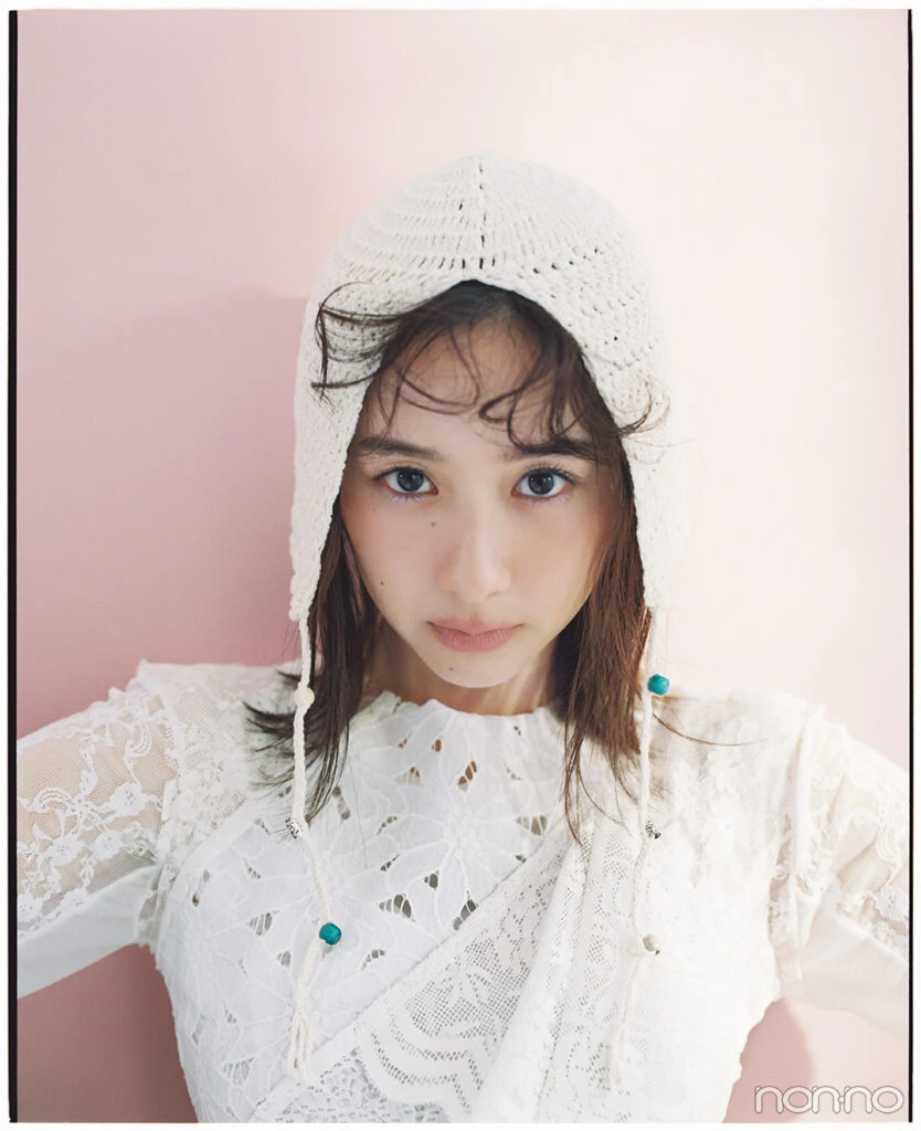 ピンクの壁前に立つ堀田真由