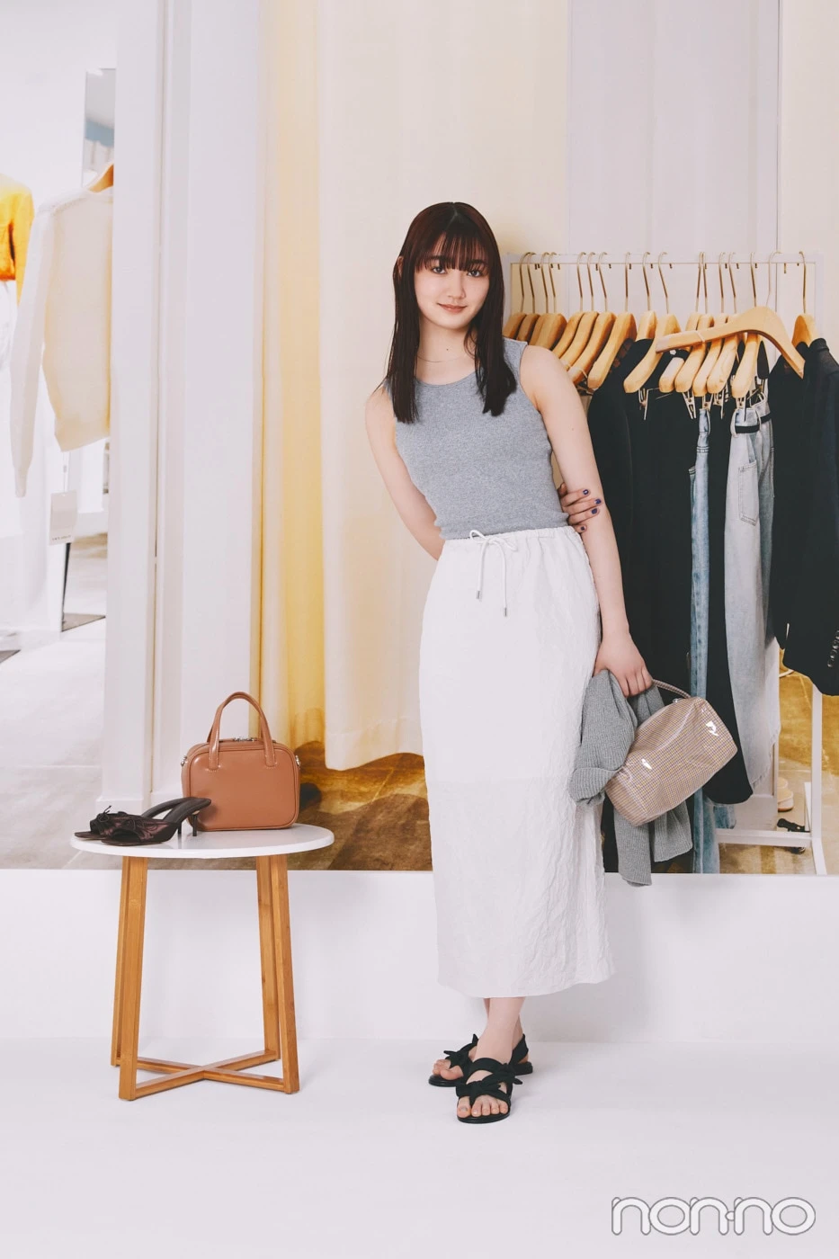 グレーのタンクに白のスカートを着た小宮山莉渚