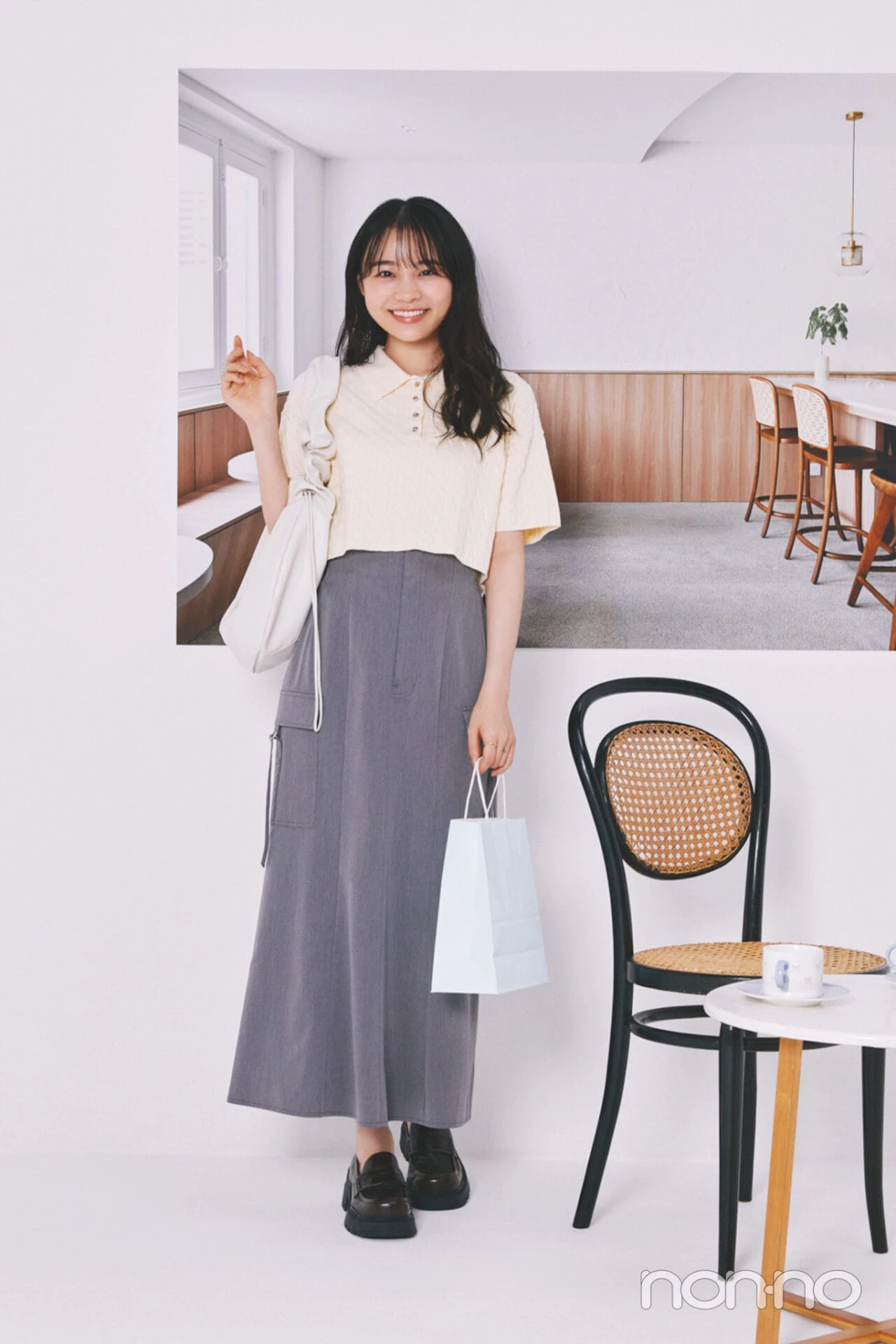 黄色のポロトップスにグレーのスカートを合わせた林芽亜里