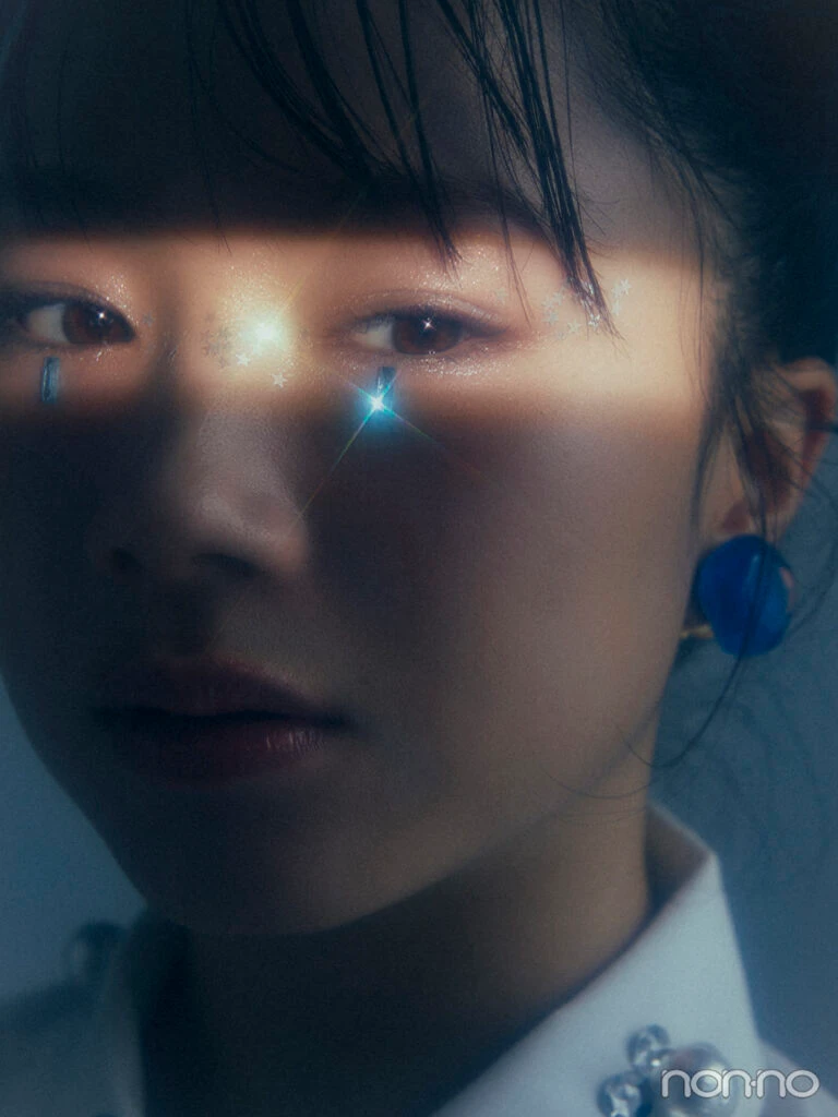 目元だけにライトが当たり、目元の青いストーンがキラリと光る、石田亜佑美さんの印象的なアップ写真