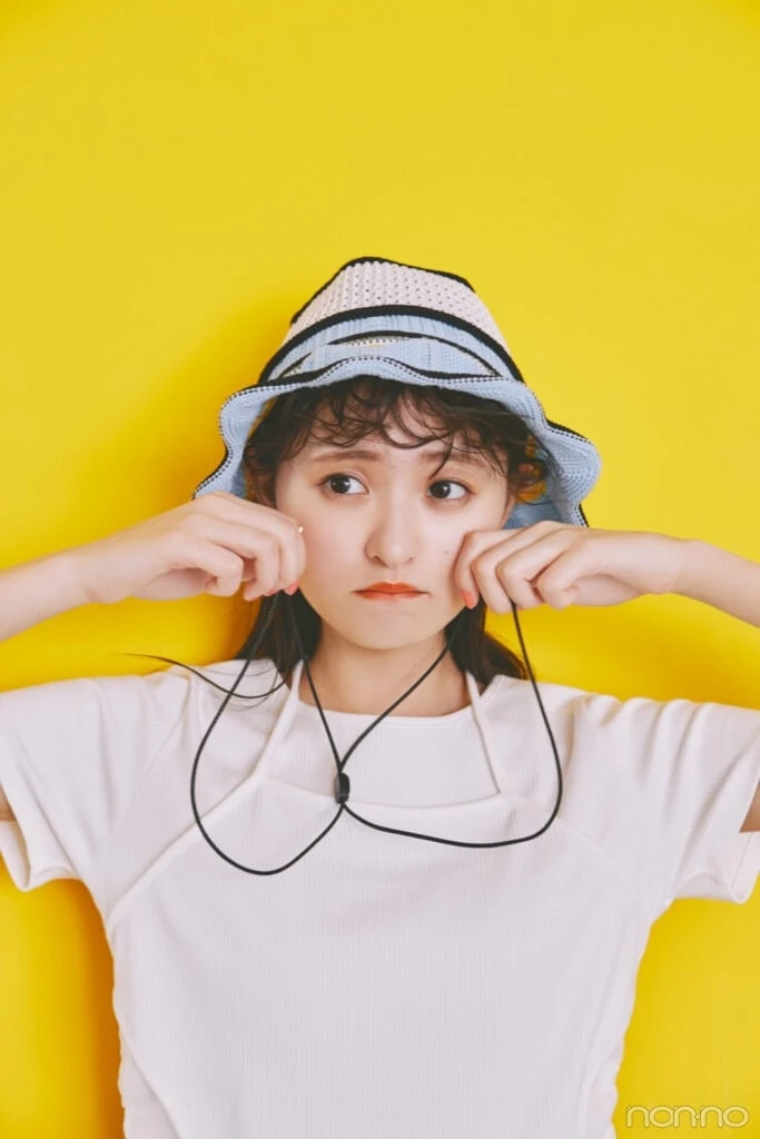 帽子の紐を持った遠藤さくらのホルターネックレイヤードTシャツの寄り