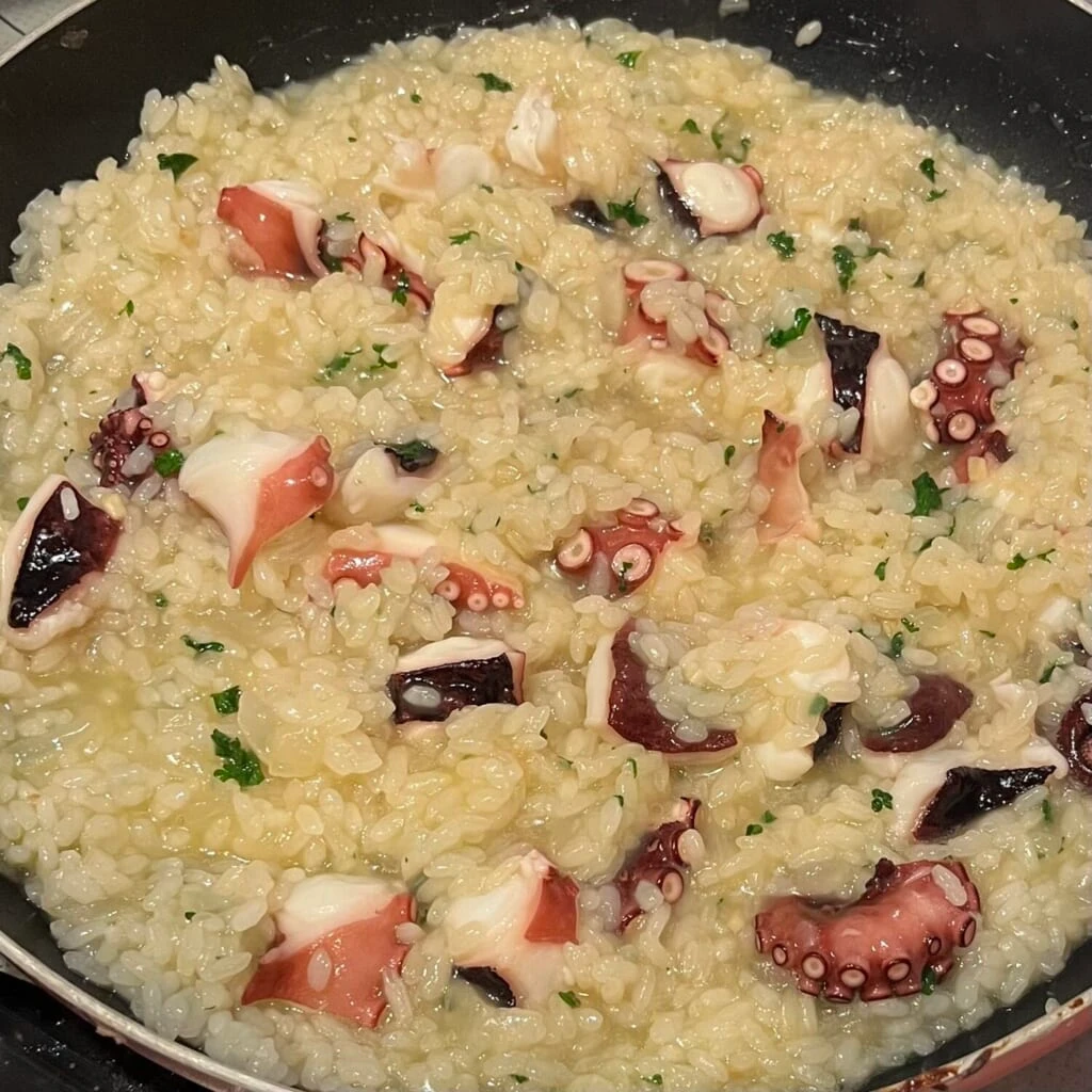 フライパンでタコのリゾットを作っている