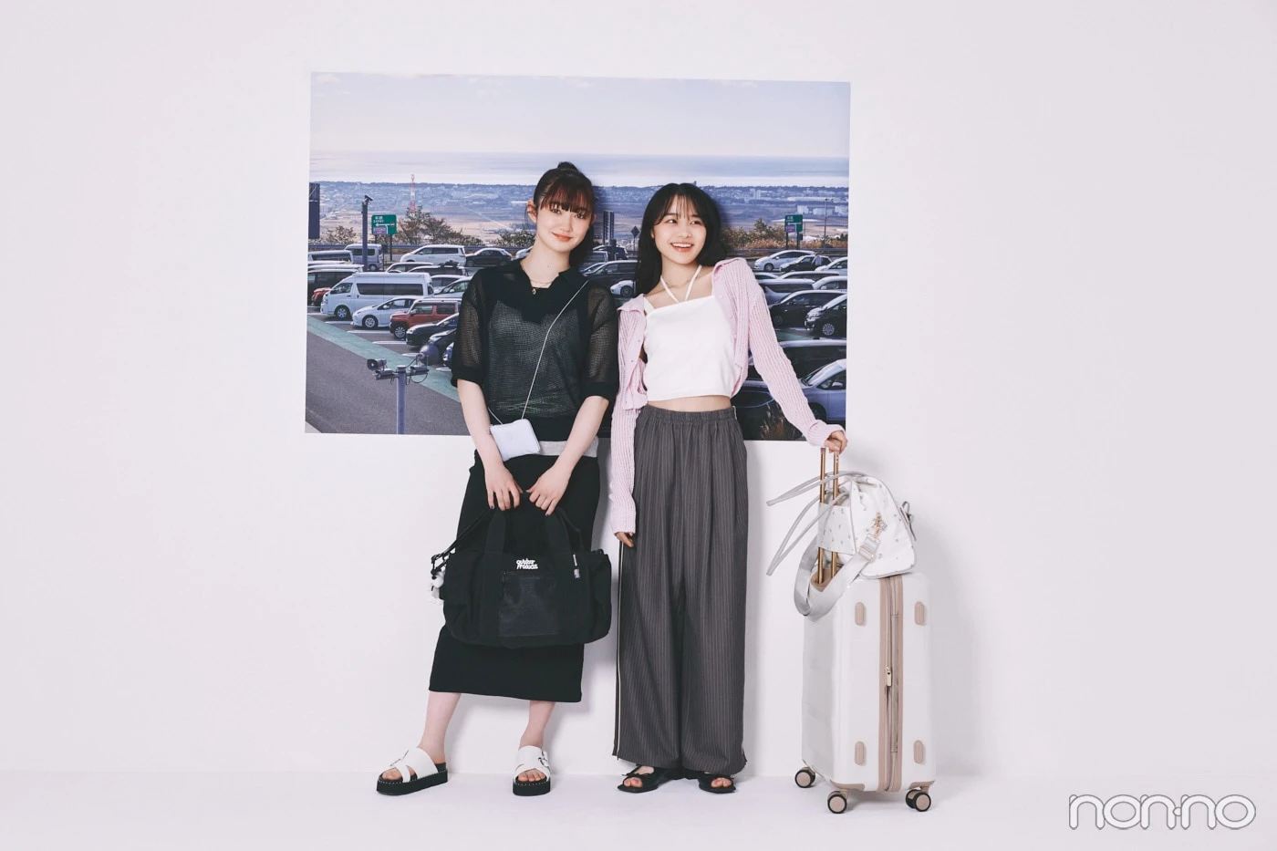 サービスエリアの写真の前に立つ林芽亜里と小宮山莉渚