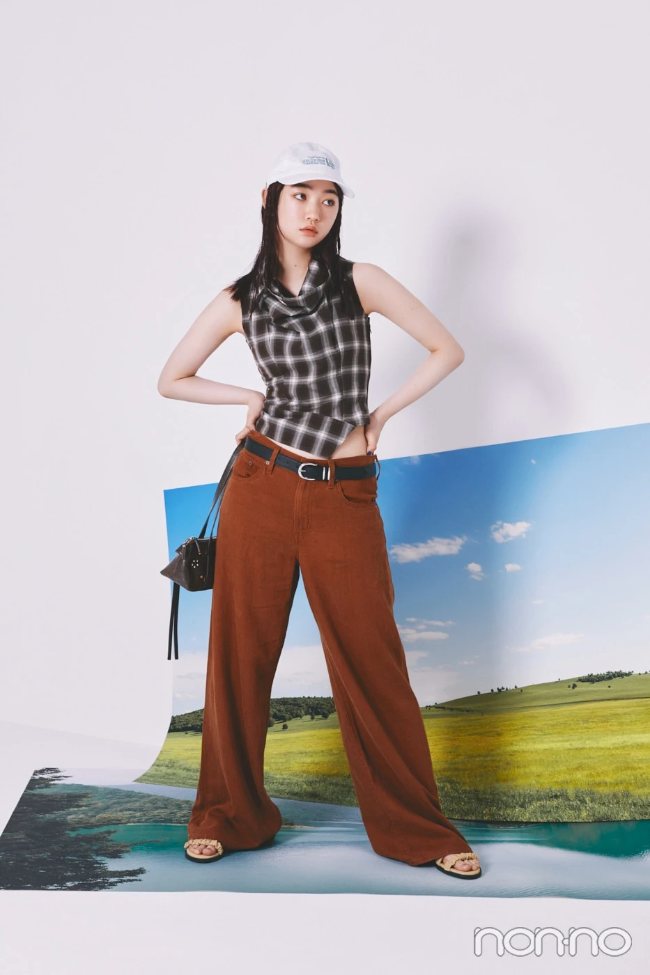 チェックのトップスに茶色のパンツを着た小宮山莉渚