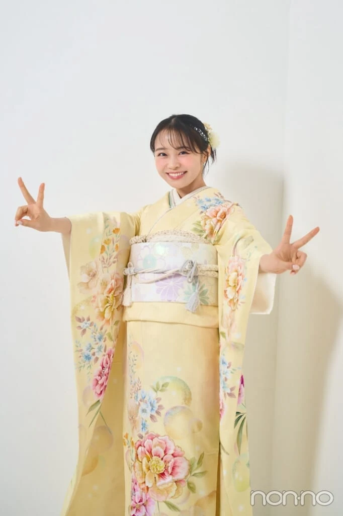 イエローの着物を着てピースする林芽亜里