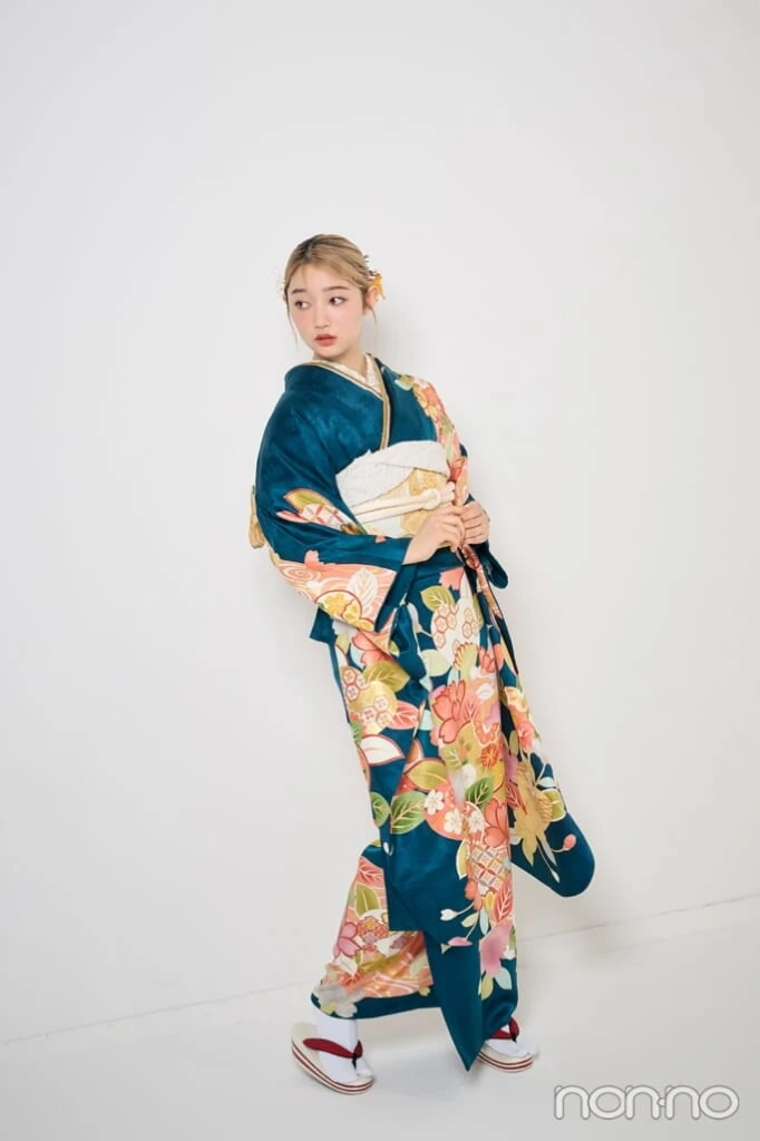 グリーンの振袖を着て横を向く小宮山莉渚の全身