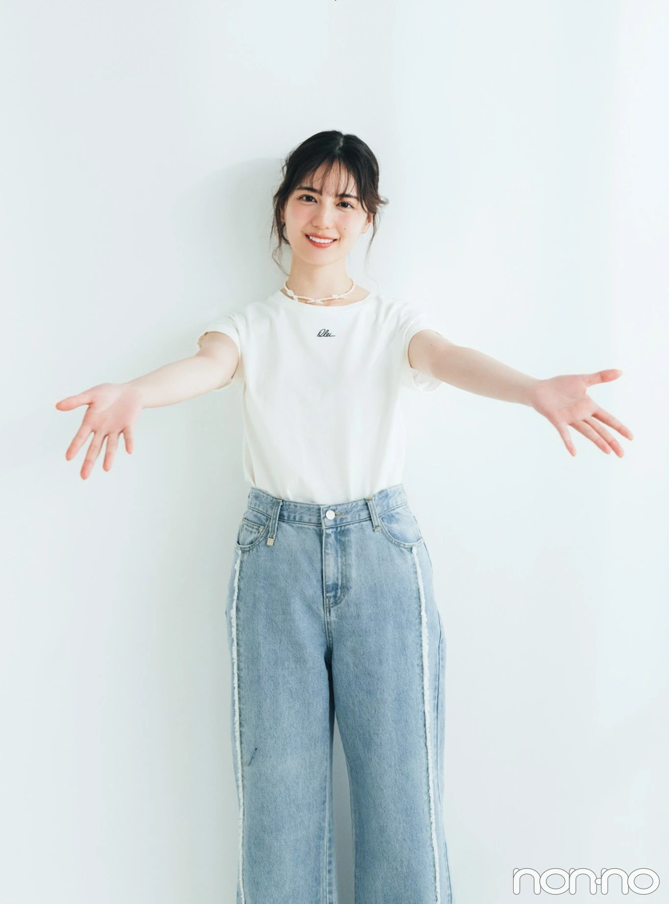 両手を広げてほほえむ小坂菜緒