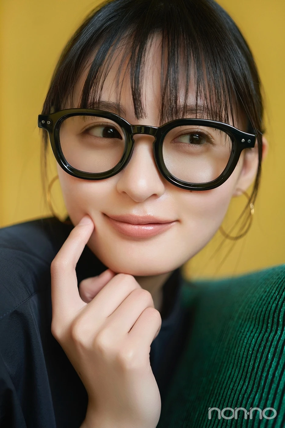黒縁メガネをかけて横を向いて笑う遠藤さくら