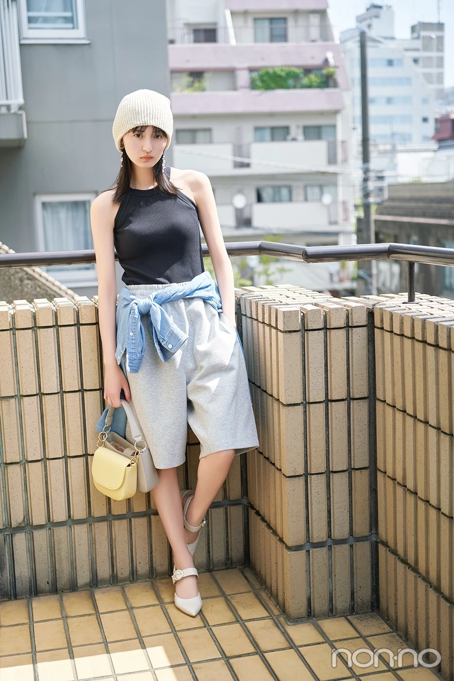 ニット帽に黒のタンクトップ、グレーのハーフパンツを履いてベランダ立つ遠藤さくらの全身