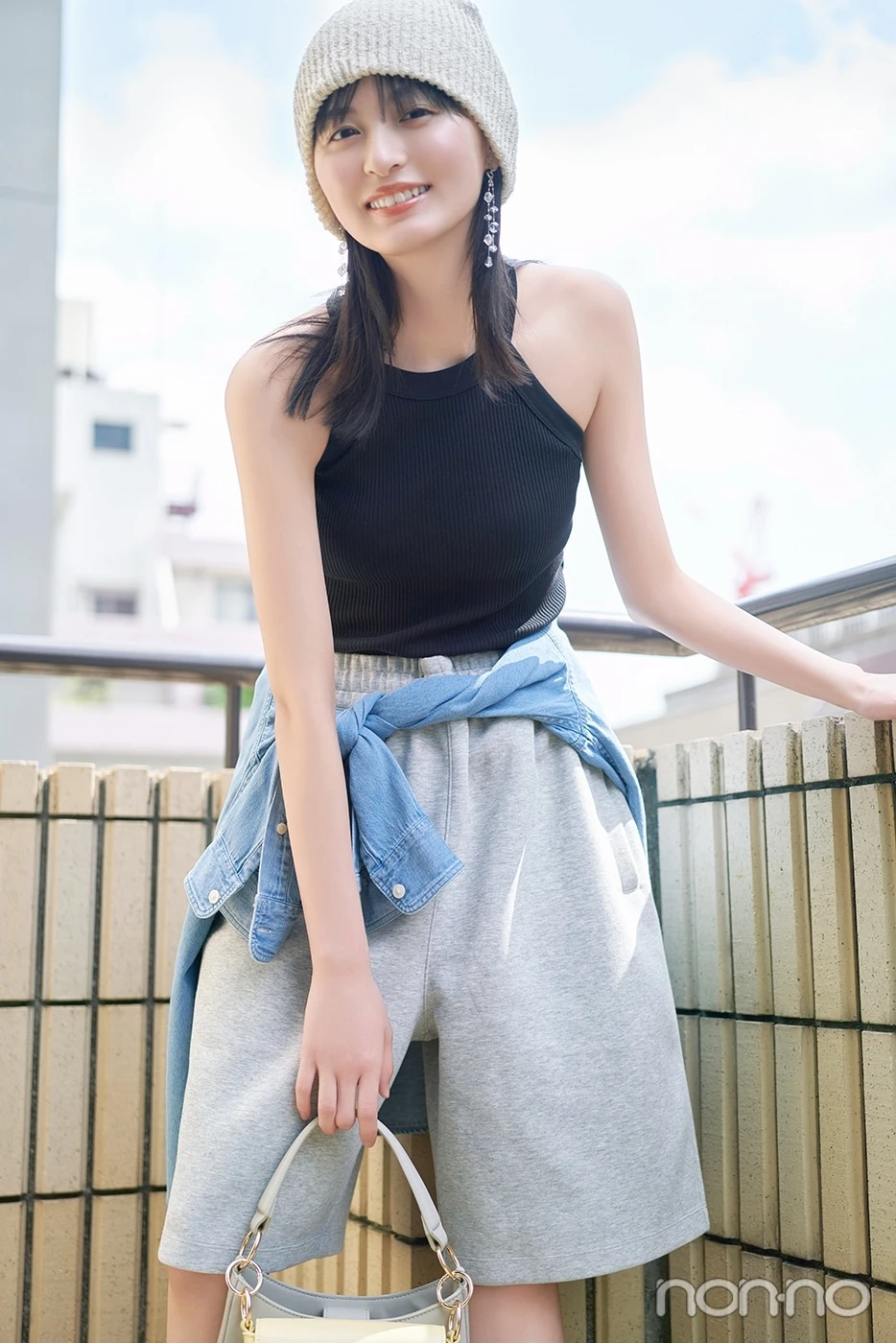 ニット帽に黒のタンクトップ、グレーのハーフパンツを履いて笑う遠藤さくら
