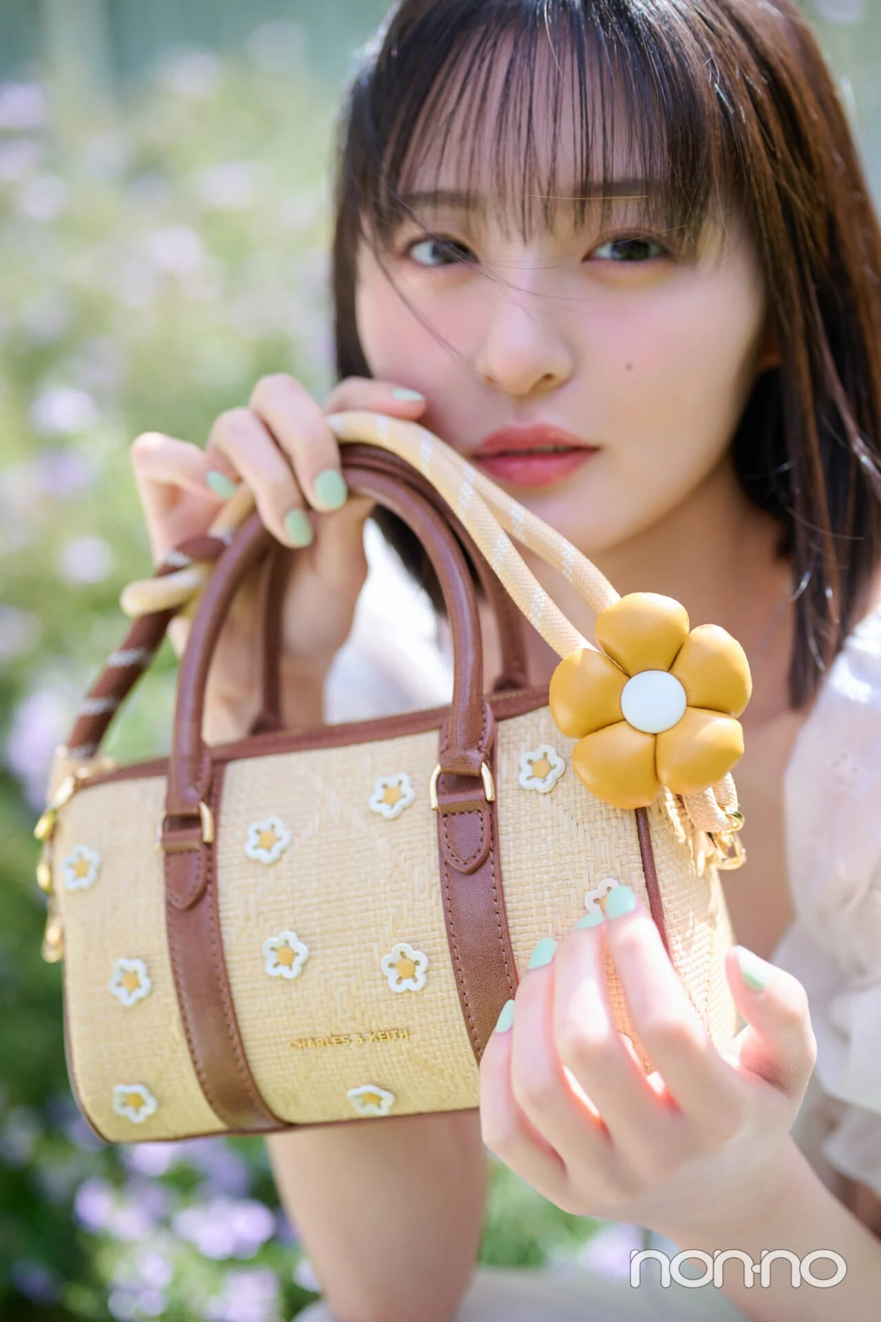 白のレースワンピを着てハンドバッグを持つ遠藤さくらの寄りカット