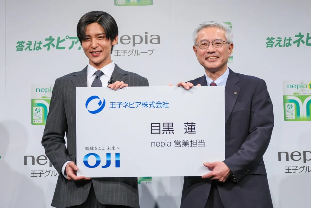 ネピア営業担当の巨大名刺を手にするSnow Man目黒蓮さんと王子ネピア社長森平高行さん