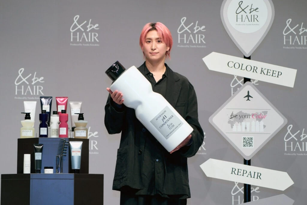 &be HAIRブランドアンバサダーとして、大きなボトルを手にしたSnow Man佐久間大介さん