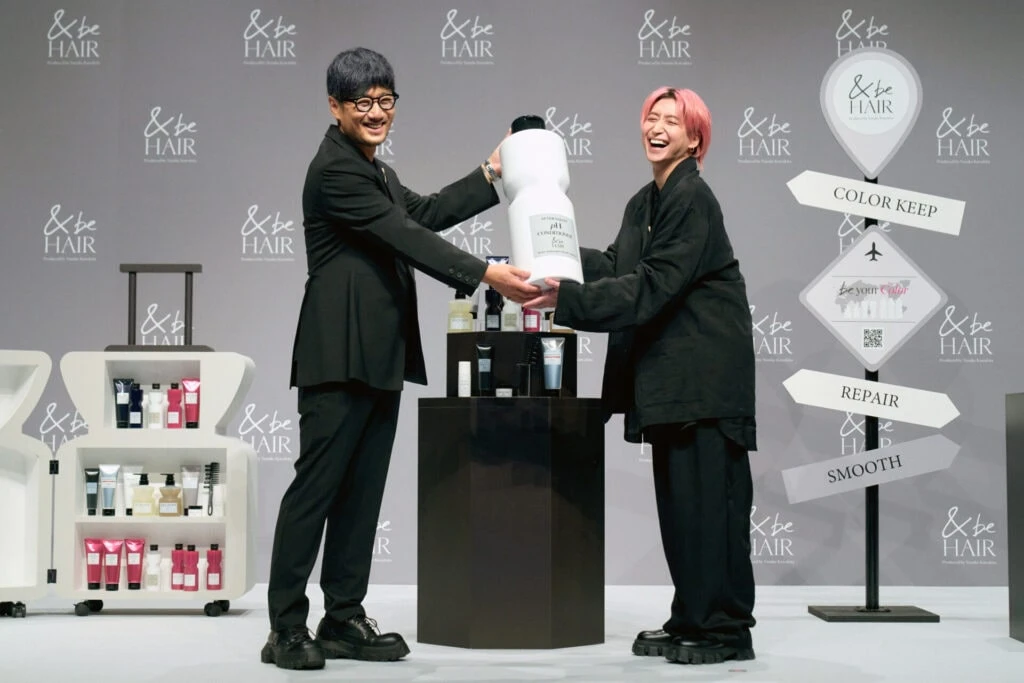 ボトル上の委任状をヘアメイクアップアーティストの河北裕介さんから手渡されるSnow Man佐久間大介さん