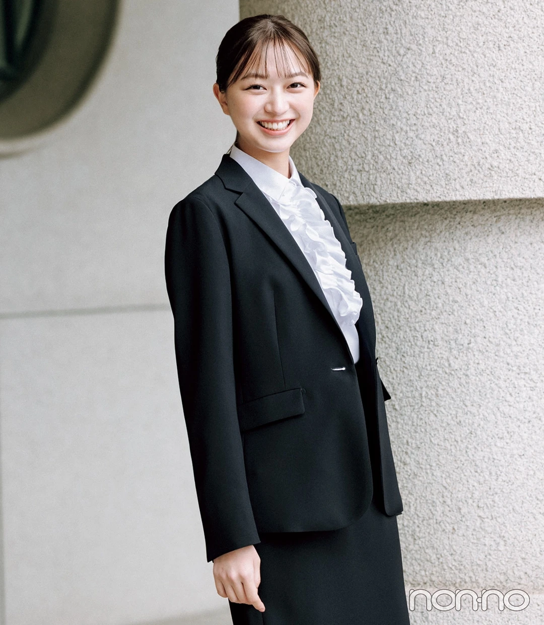 大学入学式の女性のスーツにおすすめの白のフリルブラウスを着た女性
