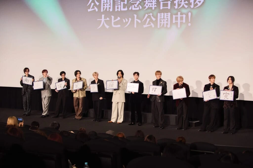 漢字一文字を書いたフリップを見せるINIメンバー