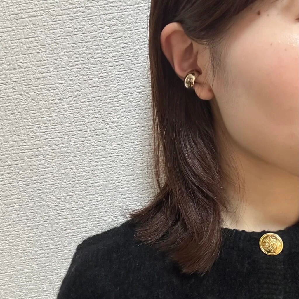 ゴールドボタンニットゴールドのピアス/イヤーカフを合わせたコーディネート