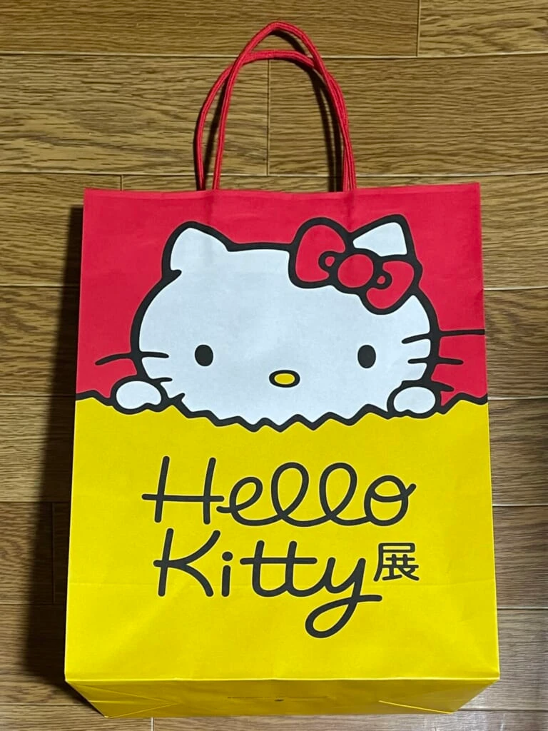 キティ展限定の紙袋。黄色い紙袋からキティが顔を出しているデザイン。
