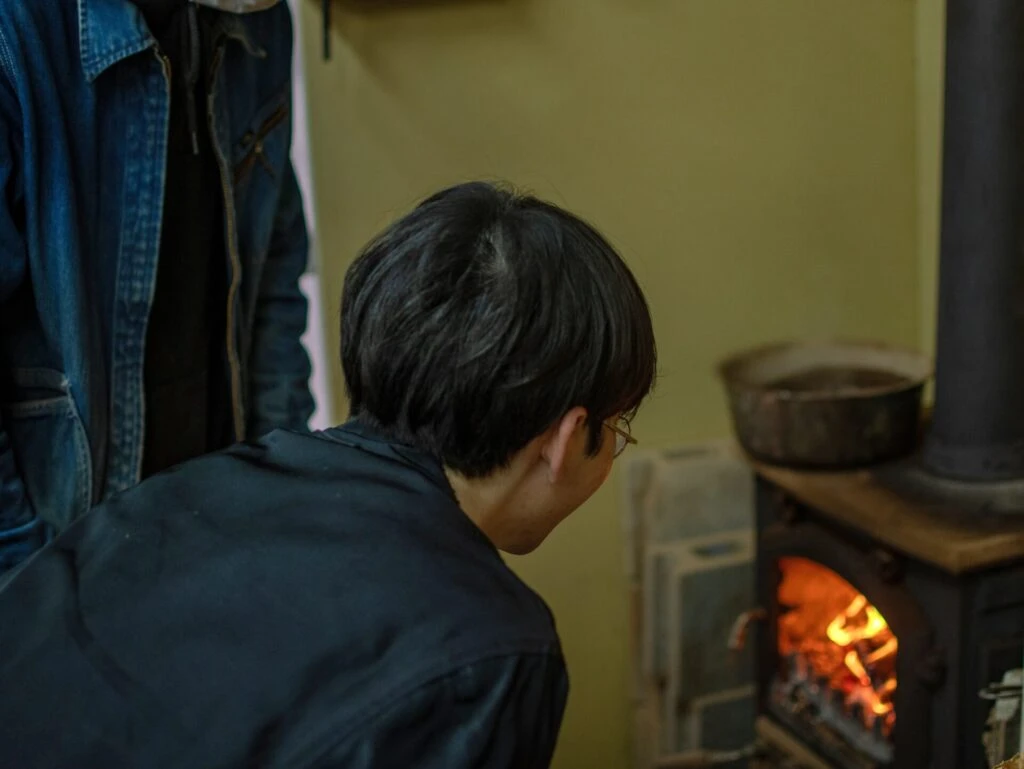 薪ストーブを興味深そうに見つめる友野一希さん
