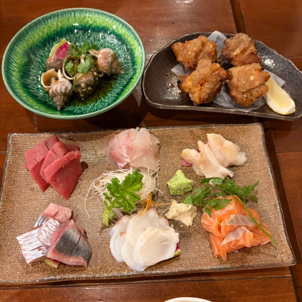 3種類の器に並んだ刺身とつぶ貝と唐揚げ