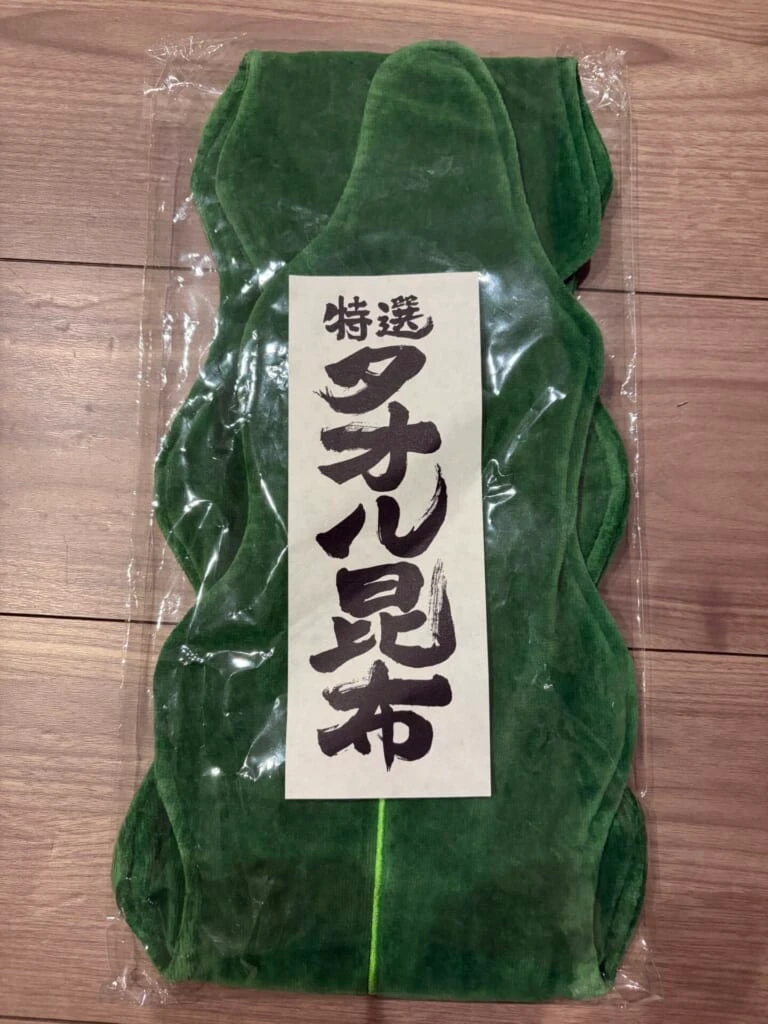 木の床に置いた昆布の形の緑色のタオル