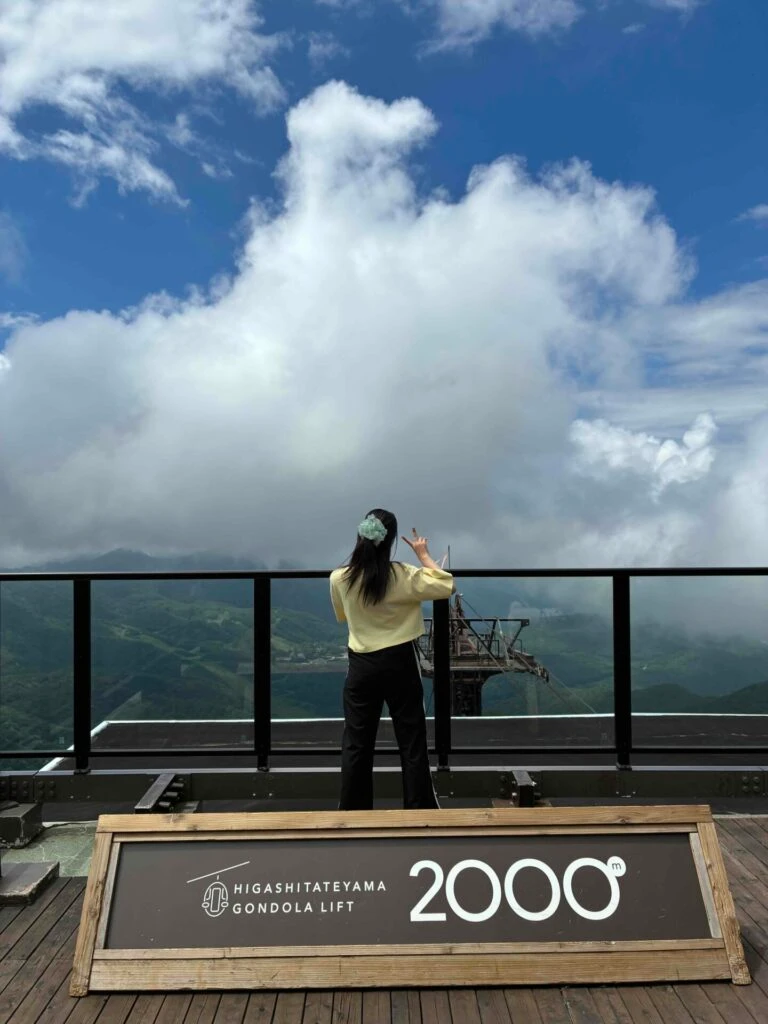 志賀高原ガーデンテラスにある2000メートルパネルと空と人の後ろ姿