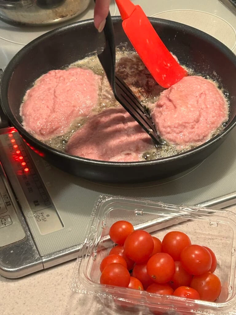 ハンバーグをヘラでひっくり返そうとしている画像