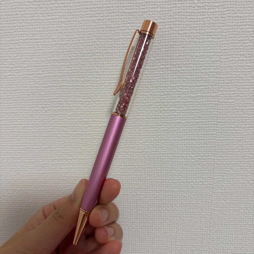 軸の上部の透明な部分にピンク色のストーンが詰まったボールペン