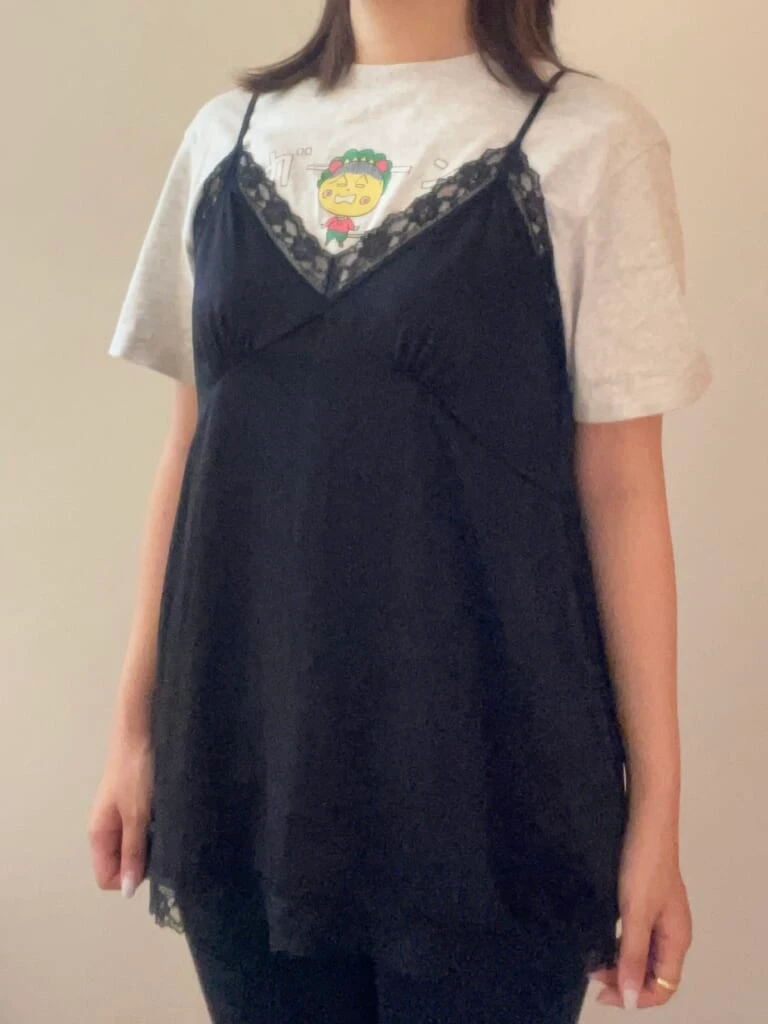 キャラクターデザインのTシャツの上からサテンキャミソール着用