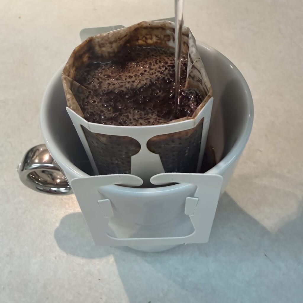 ドリップバッグにお湯を注いでコーヒーを抽出している様子