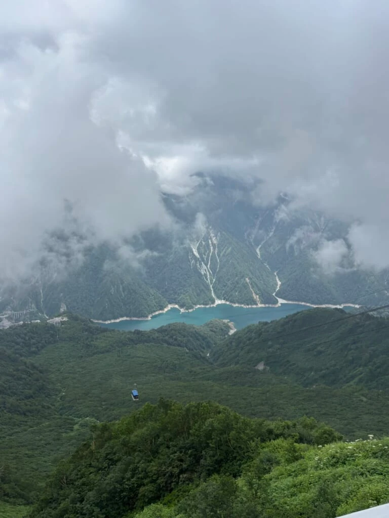 大観峰の雲上テラスから見下ろす黒部湖とロープウェイ