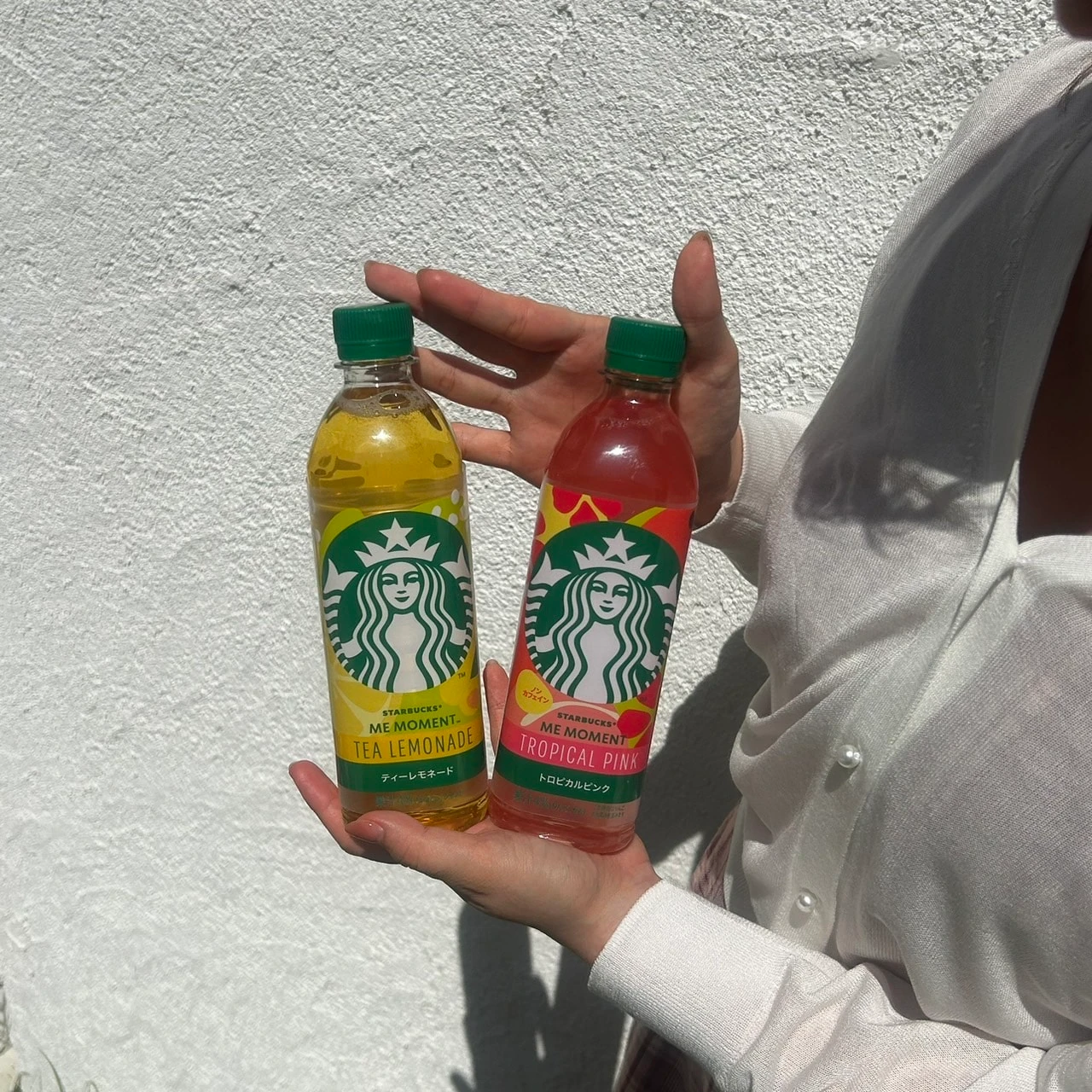 スターバックス® ME MOMENT™ ティーレモネードと スターバックス® ME MOMENT™ トロピカルピンク™を手に持った写真
