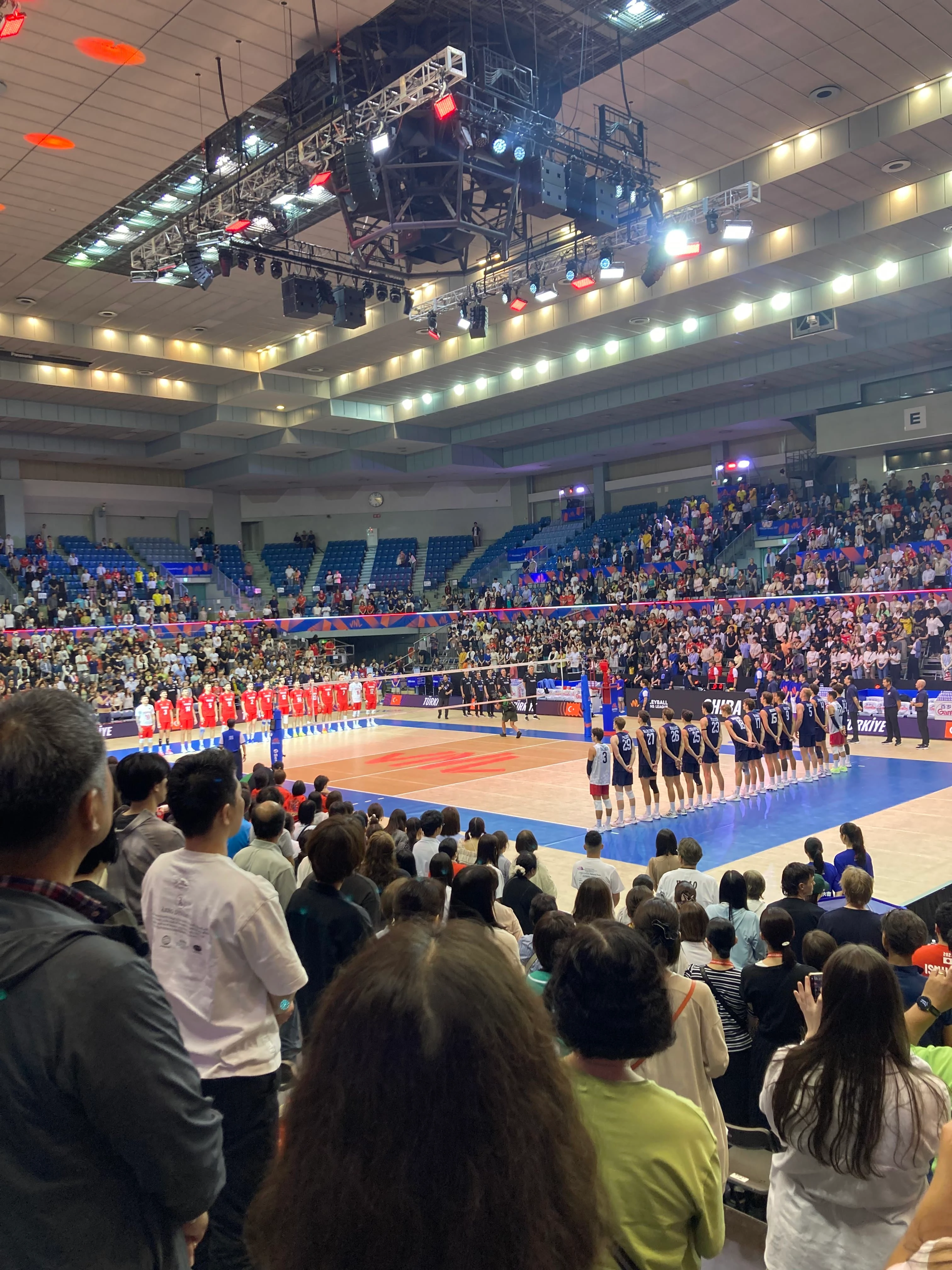 国歌を聞いている選手と観客