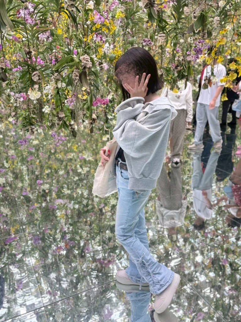 花を背景に女子が写っている