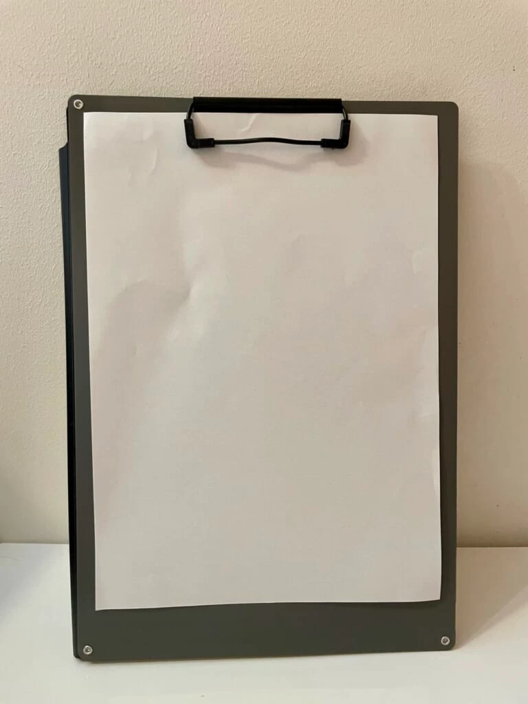 クリップで書類をはさんで、左側を後ろに折りたたんでいる