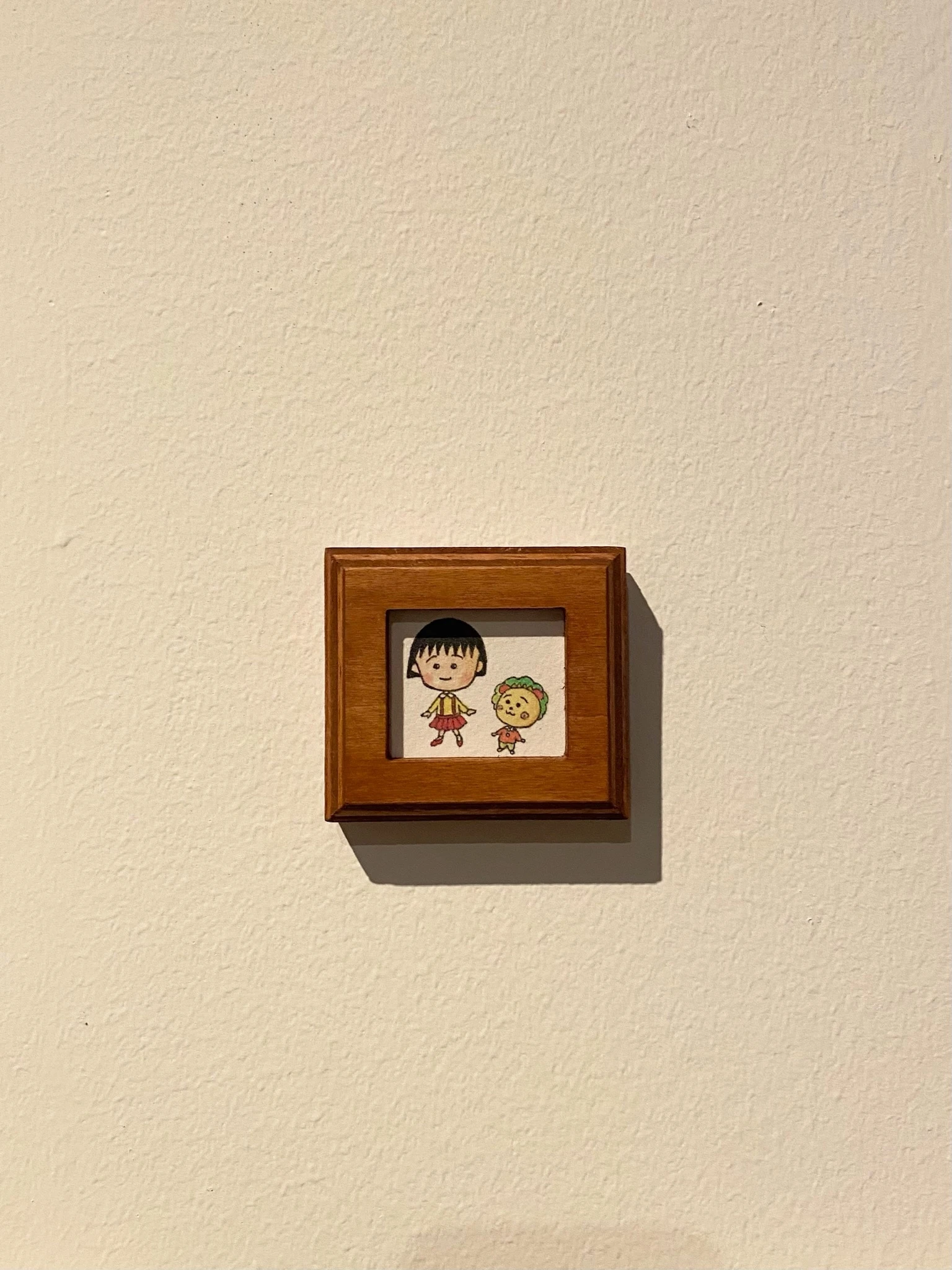 「さくらももこ展」のまる子とコジコジが手を繋いでいるイラスト。