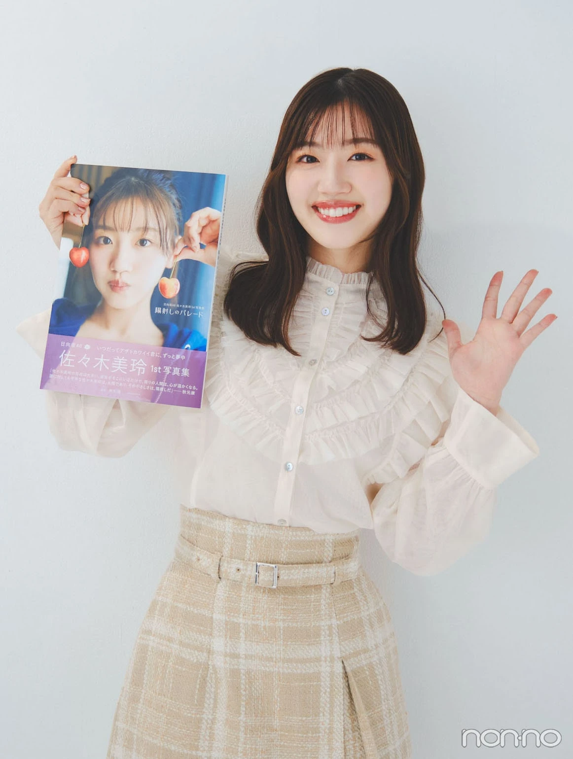 写真集を持って笑顔の佐々木美玲