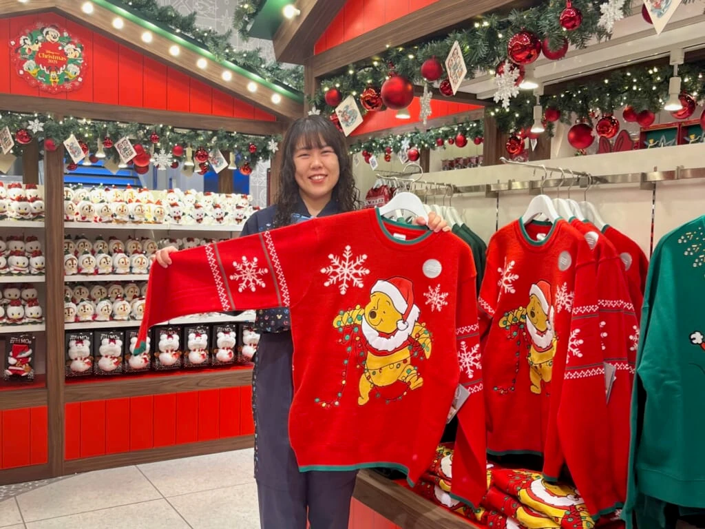 プーさんの光るセーターを持っている店員さんの写真