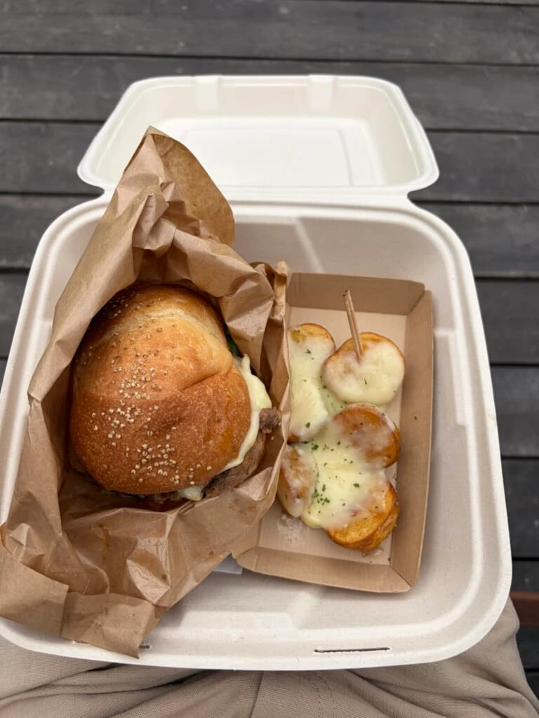 ラクレットチーズをかけたバーガーとポテト