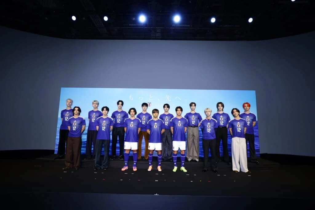 サッカー日本代表の南野拓実選手、久保建英選手、中村敬斗選手と壇上で撮影するJI BLUE