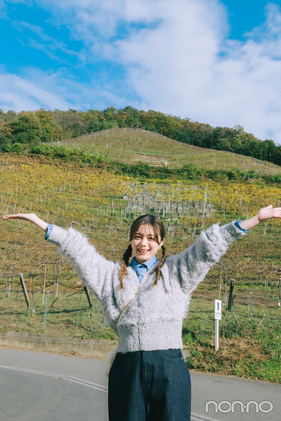 山を背景に手をあげる紺野彩夏