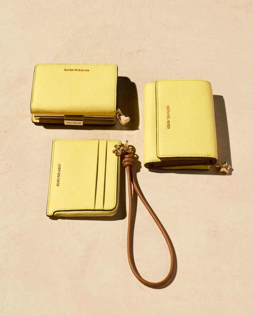 マイケル・コースのレモン色の財布。(右)三つ折り財布。”ブライアント”トライフォールド ウォレット、(左上)がま口タイプの財布。”ジェットセット”コインウォレット ミディアム、(左下)ハンドストラップつきのカードケース。”ジェットセット”カードケース リスレット スモール。