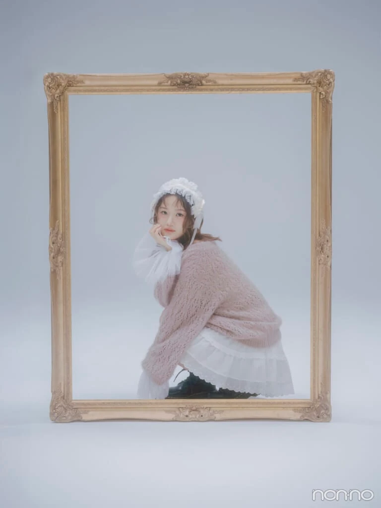 大きな額縁の中で絵のように座ってこちらを見ている横山玲奈さん