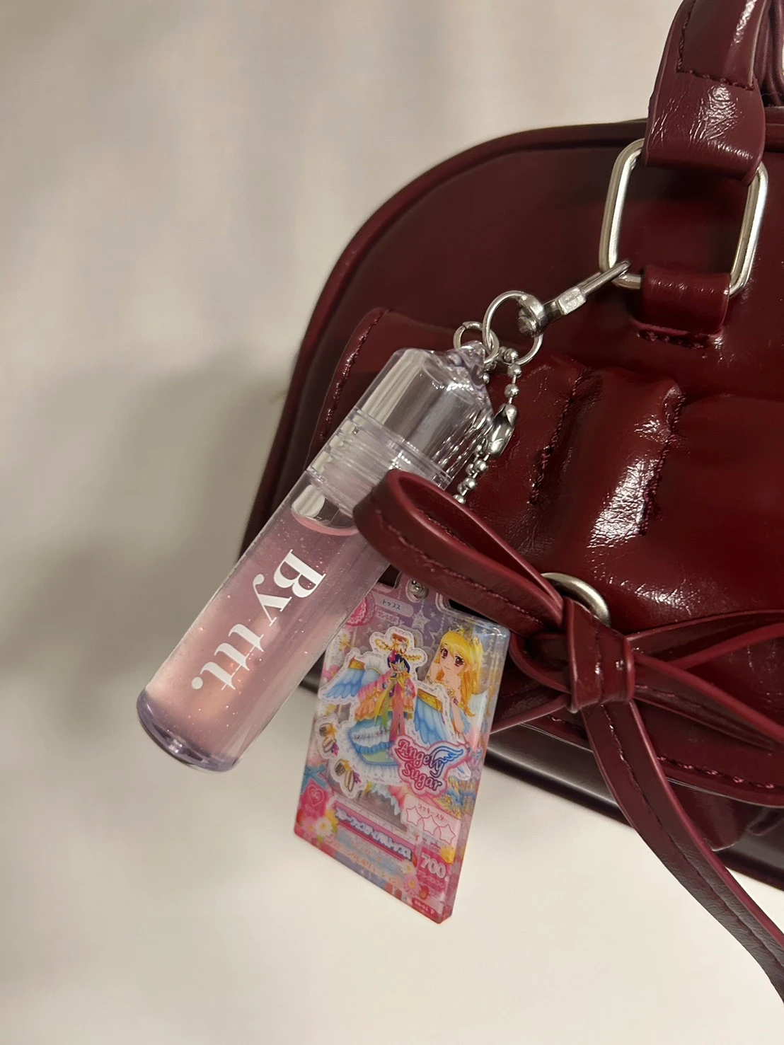 赤のカバンにキーホルダー型のグロスとアイカツチャームを付けた画像