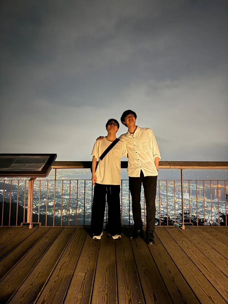 摩耶山の夜景をバックに写真を撮る友野一希さん、島田高志郎さん