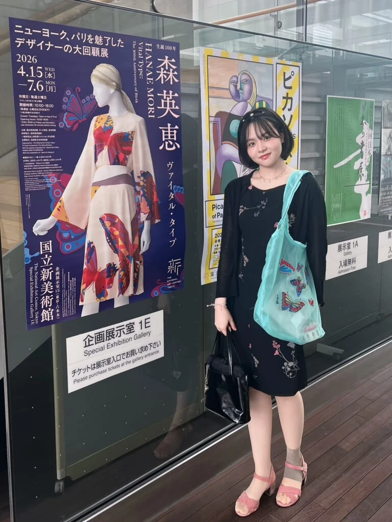 人物　「森英恵　ヴァイタルタイプ」のポスターの前に立つ