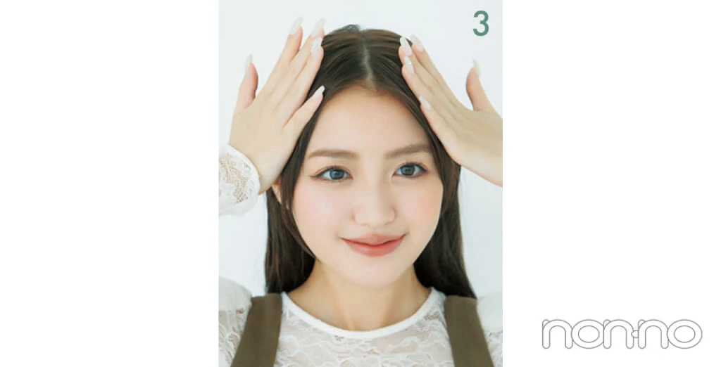 ヘアワックスを手で前髪につけている女性