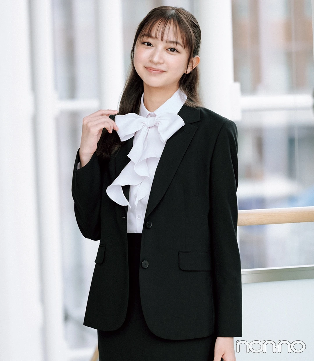 大学入学式の女性のスーツにおすすめのピンクのボウタイブラウスを
着た女性